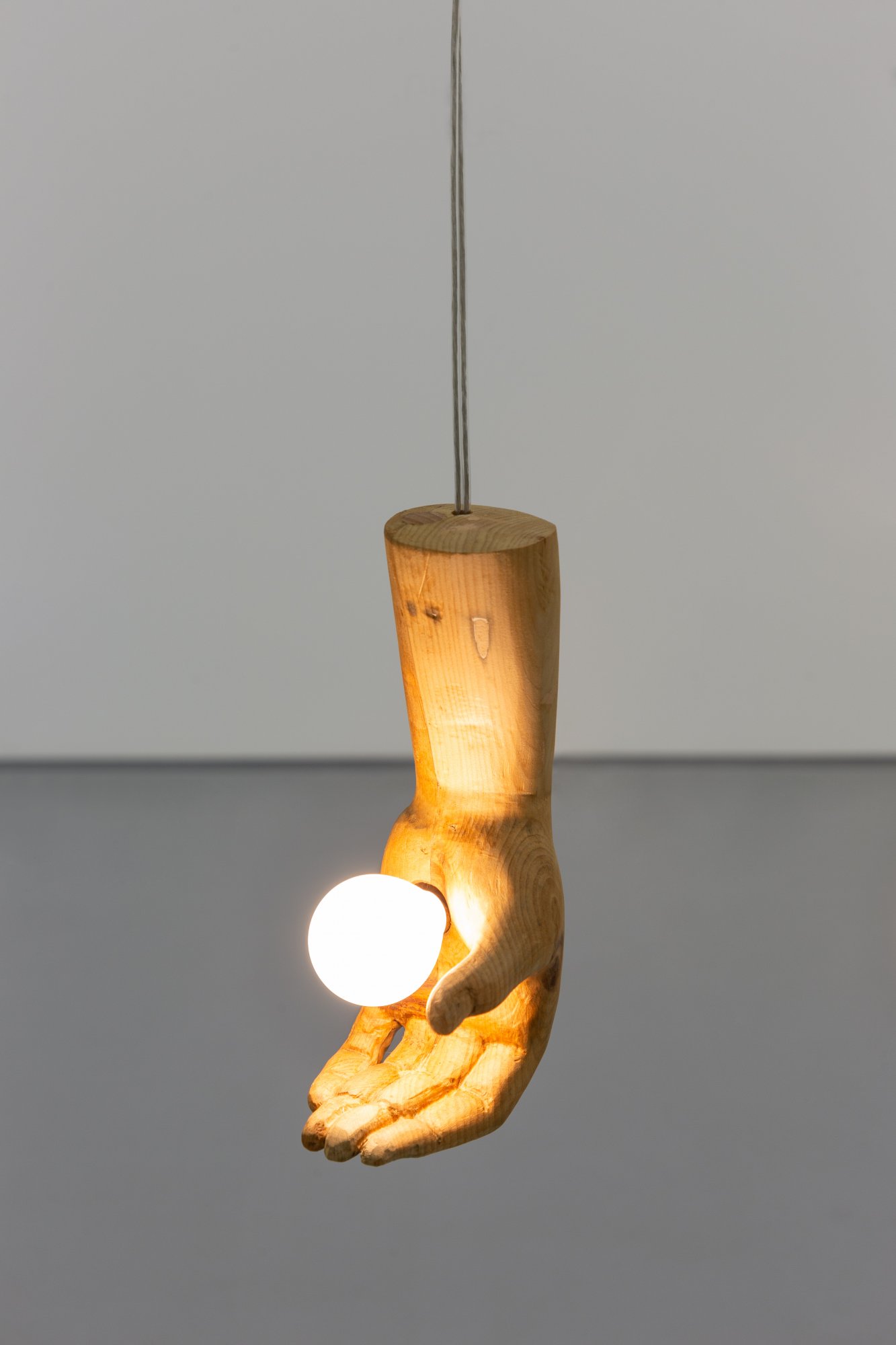 André Romão, The visitor (left), 2022. Re-worked sculptural fragment (wood, probably Spain, late 1700s), wood, electrical components, light bulb. 21 × 12 × 9 cm. Unique
