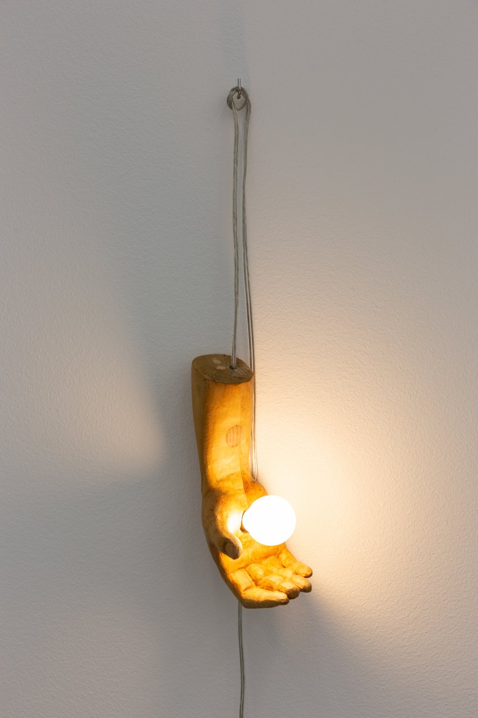 André Romão, The visitor (right), 2022. Re-worked sculptural fragment (wood, probably Spain, late 1700s), wood, electrical components, light bulb. 21 × 12 × 9 cm. Unique
