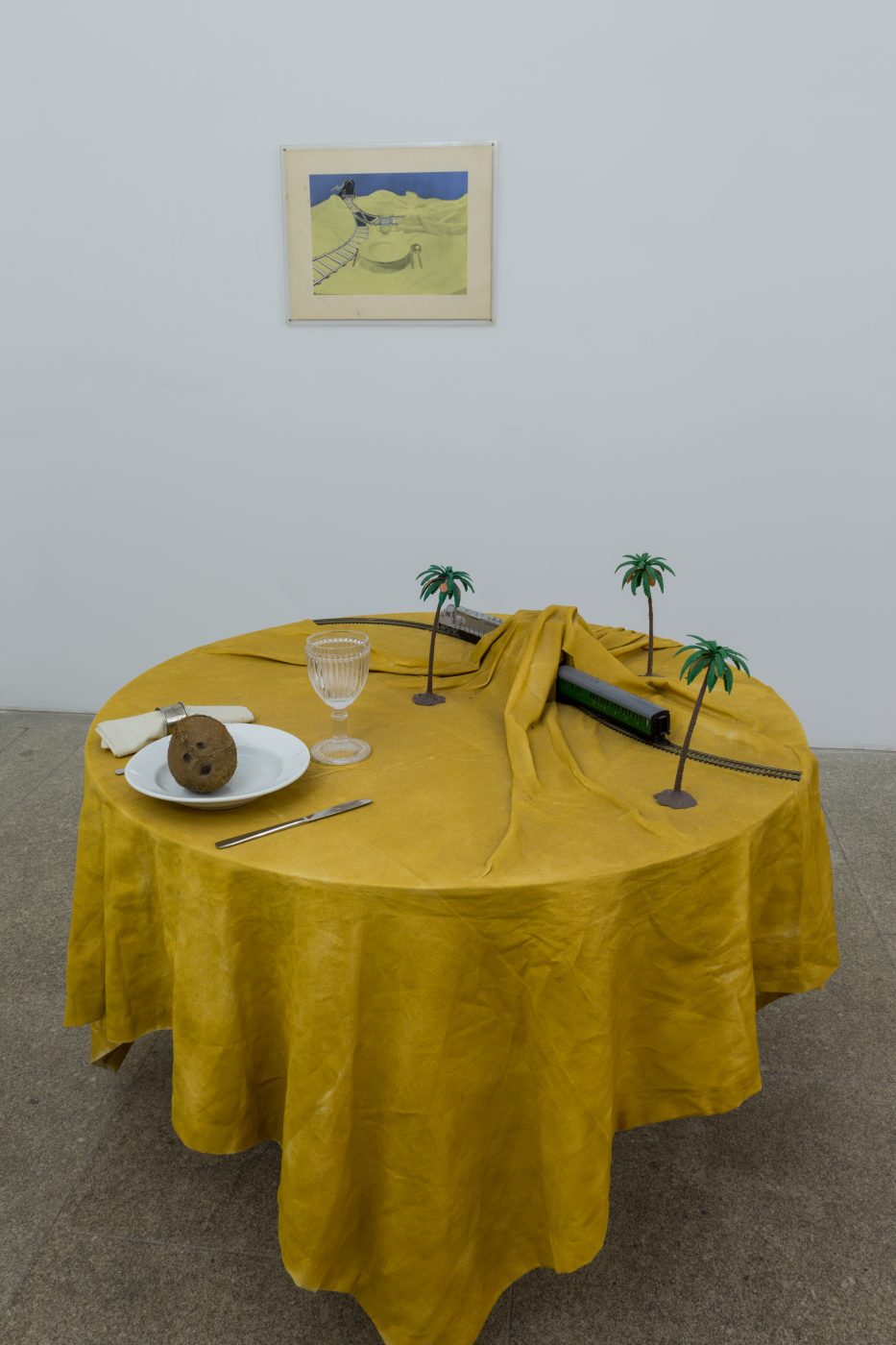 Ana Vieira, Mesa-Paisagem, 1973. 94 x Ø 110 cm.  Wooden table, fabric, spray paint on fabric, metal, ceramics, and objects (1 plate, cutlery, napkin ring, napkin, sand, boat). Unique
