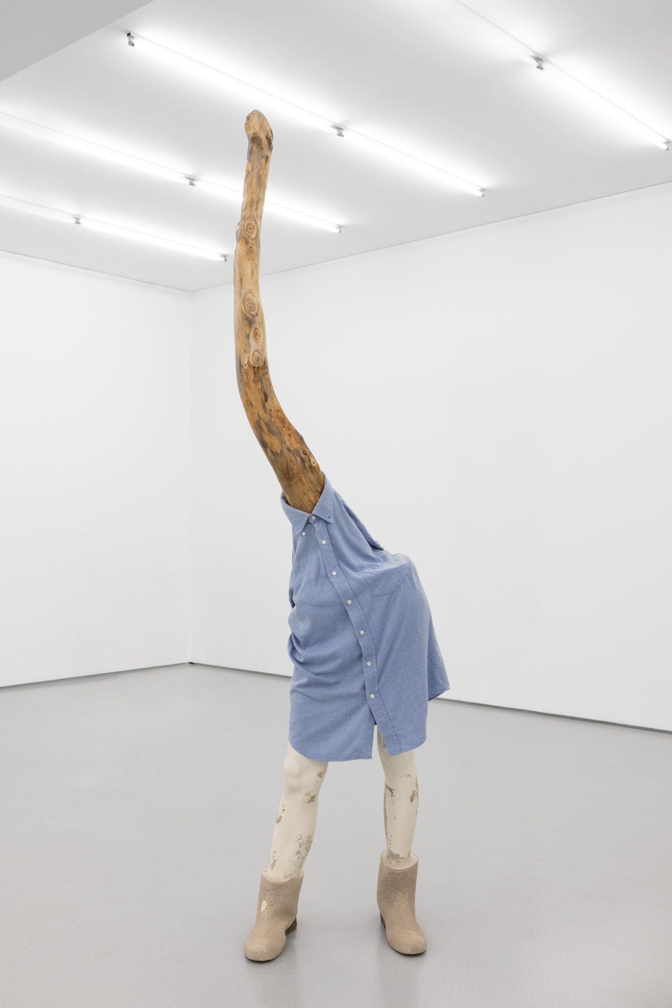 Susanne S. D. Themlitz, Grown-Up/ Crescida, 2025. Wood, cotton shirt, fiberglass, cement. 205 x 50 x 33 cm.
