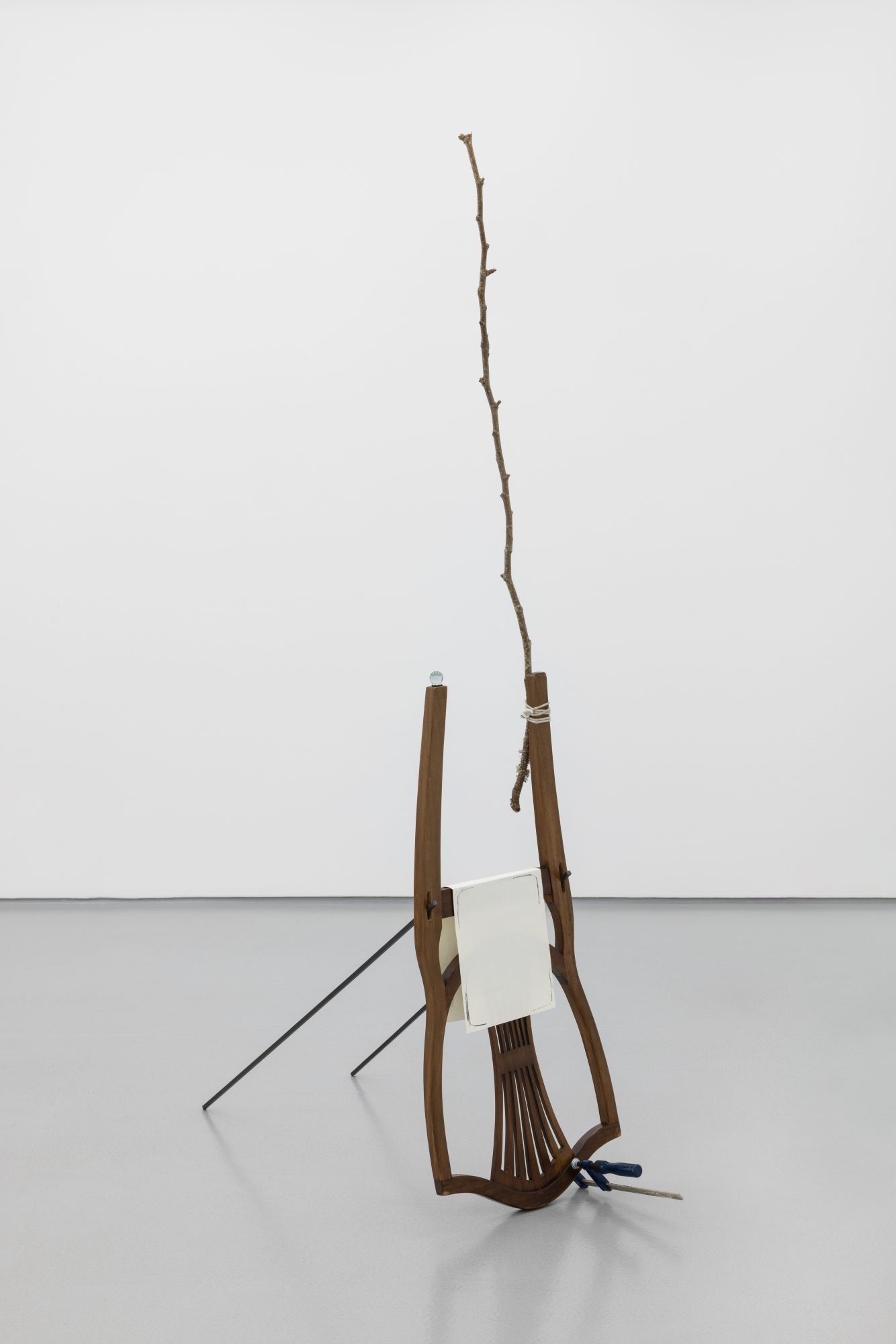 Susanne S. D. Themlitz, Drawing (Iceberg)/Desenho (Iceberg), 2025. Wood, glass sphere, elastic band, graphite on paper, iron, staple. 188 x 100 x 39 cm.
