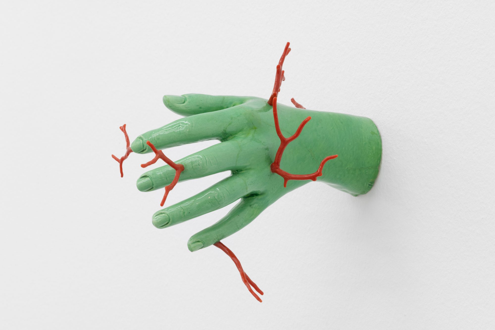 André Romão, Ferida Fóssil / Fossil Wound, 2026. Sculptural fragment (glazed ceramic, France, c. 1960), mediterranean red coral. 16 x 22 x 14 cm
