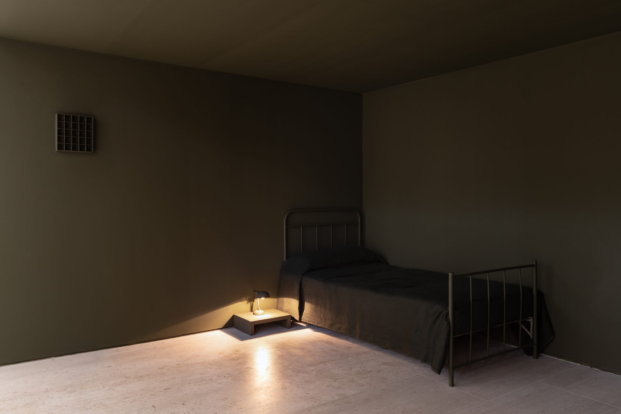 Carlos Bunga, The Place Where We Daily Abandon the World (detail), 2021. Metal bed, mattress, pillow, fabric, lamp, bedside table, wall paint, painted cardboard structure, masking tape, glue paint-soaked t-shirt, hanger. Variable dimensions. Ed. 1
